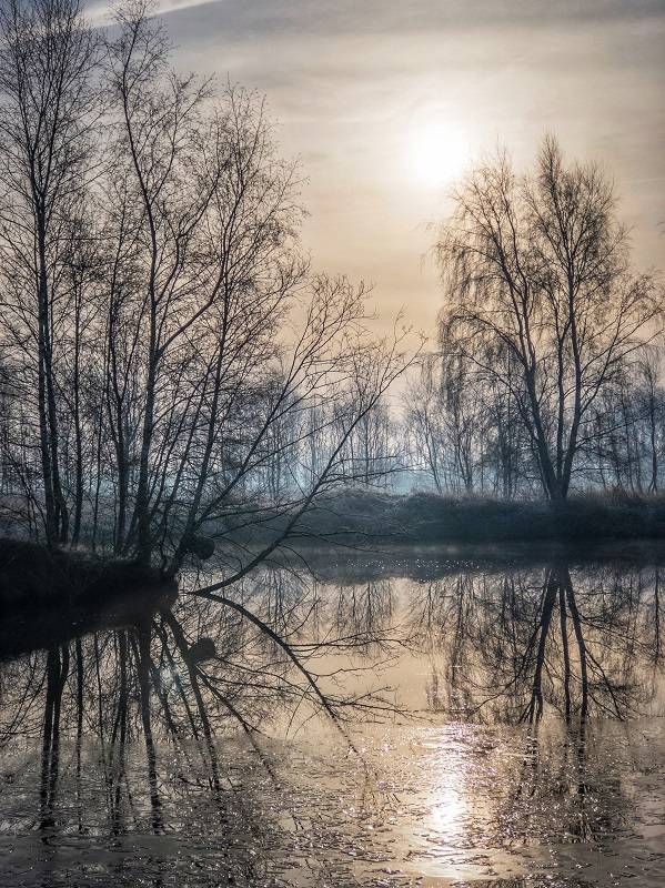 A winter landscape with reflections in the water. iPhone photo. iPhone landscape photography