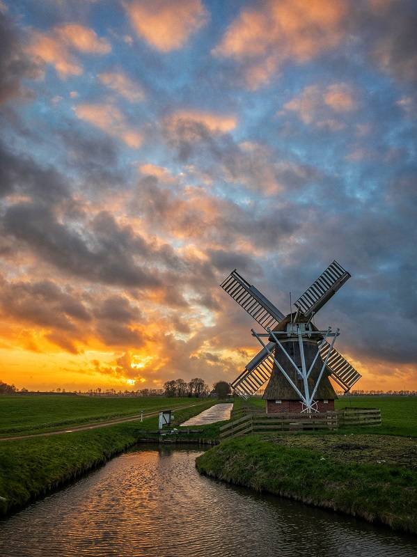 Landschappen fotograferen met een iPhone. Op deze foto is een molen te zien en een zonsondergang.